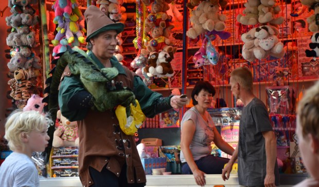 De drakentemmer deelt muntjes uit op de kermis