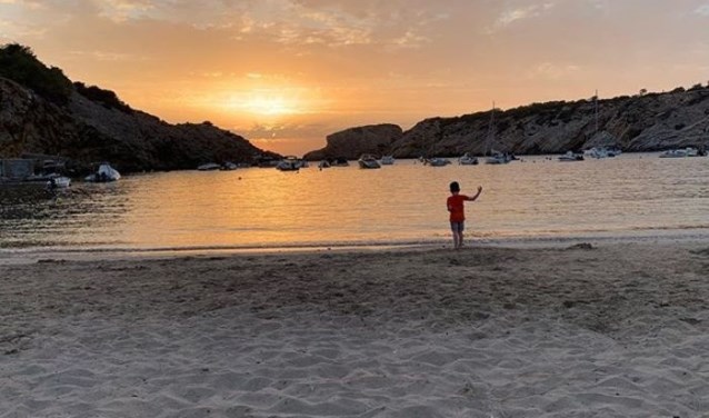 De kleinzoon van Anja Klomp geniet van de zonsondergang op het strand van Ibiza.