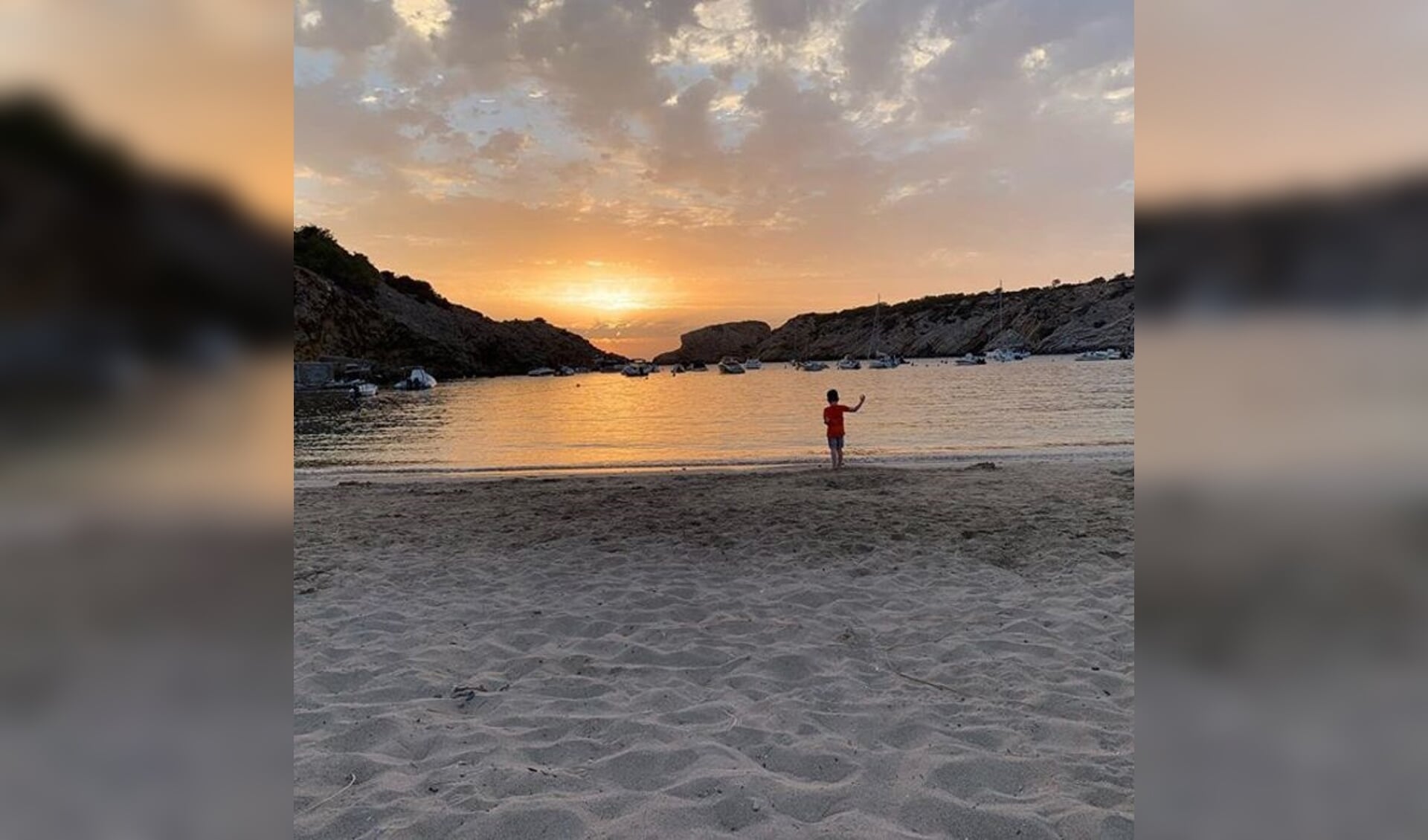 De kleinzoon van Anja Klomp geniet van de zonsondergang op het strand van Ibiza.