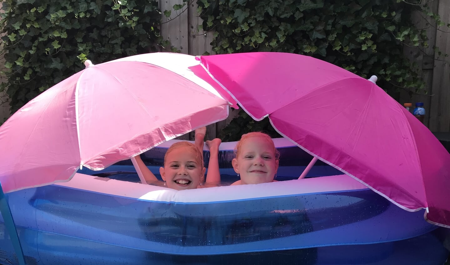 De twee oudste dochters van Agnes Furster, Julia en Rosalyn, maakten in het zwembadje met twee parasols een soort van tentje.