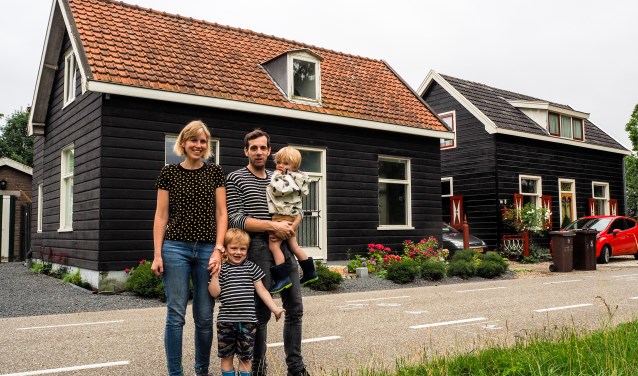 Annelies en Lucas poseren met hun twee zoontjes Olivier en Jens voor hun houten huis aan de Koningslaan.