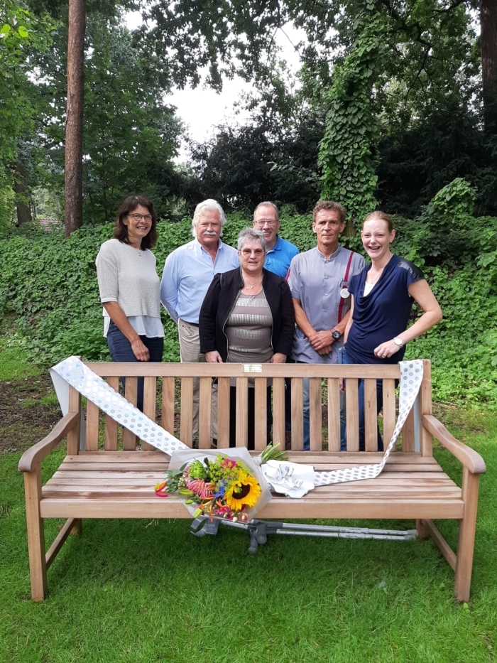 Familie en medewerkers bij de gechonken tuinbank