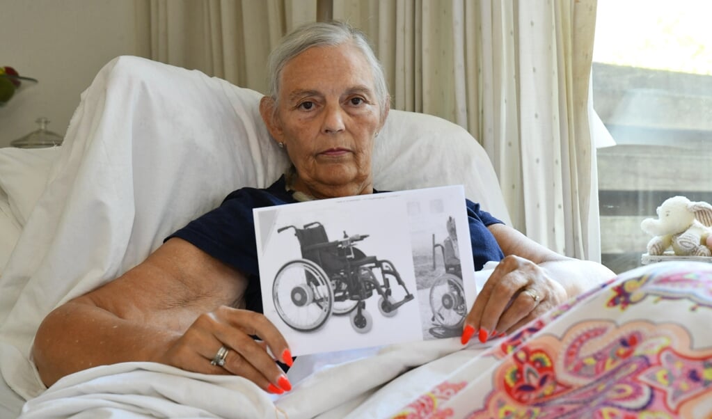 Anky toont een foto van de rolstoel, met de gewenste hulpstukken.