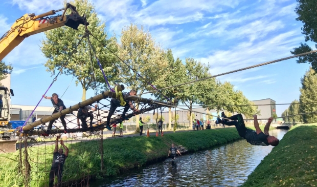 <p>Hindernis over water met fanatieke deelnemers.</p>