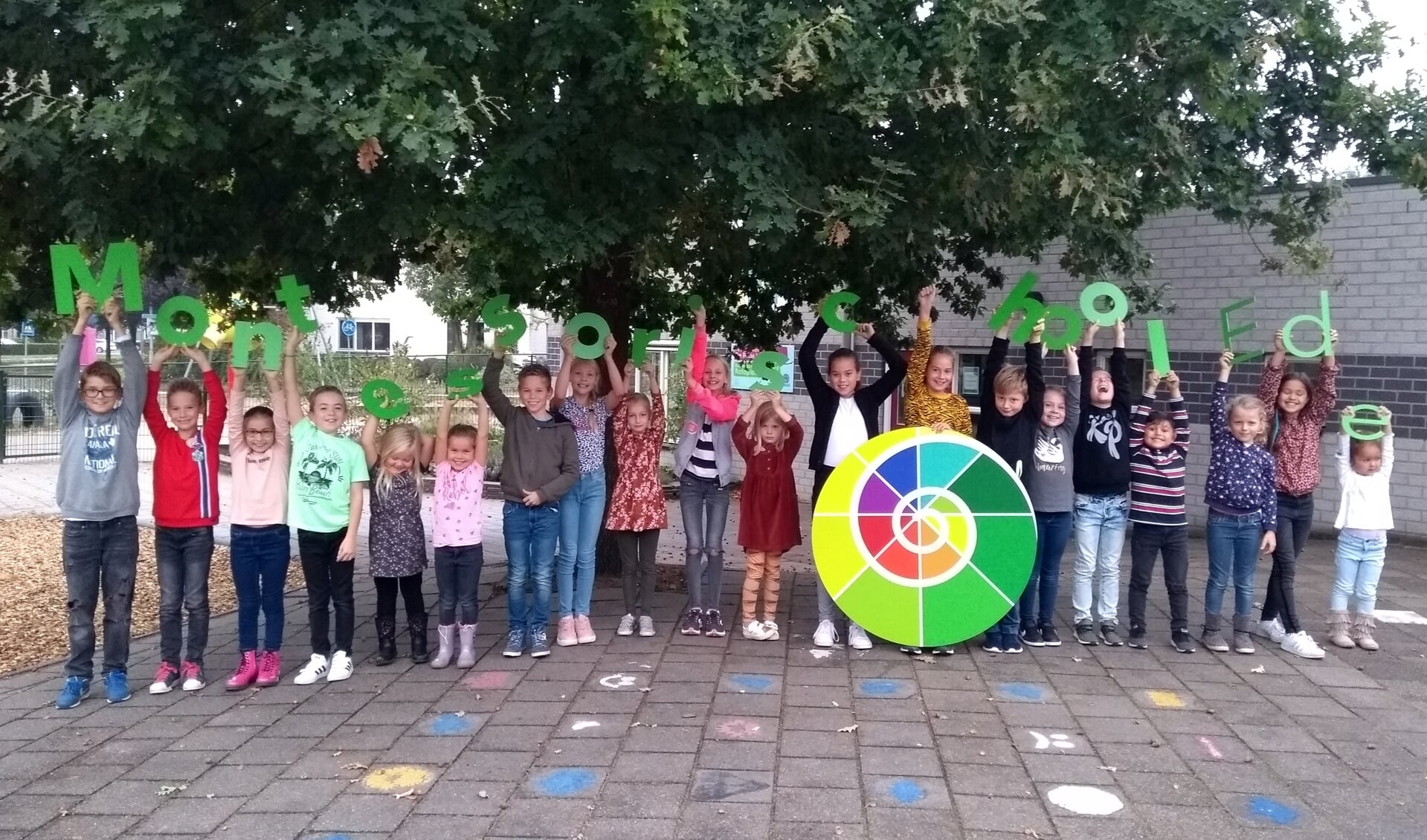 Leerlingen van de Montessorischool houden het nieuwe Logo vast