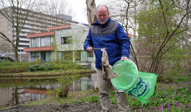 Bewoner ruimt zwerfafval op tijdens eerdere schoonmaakactie.