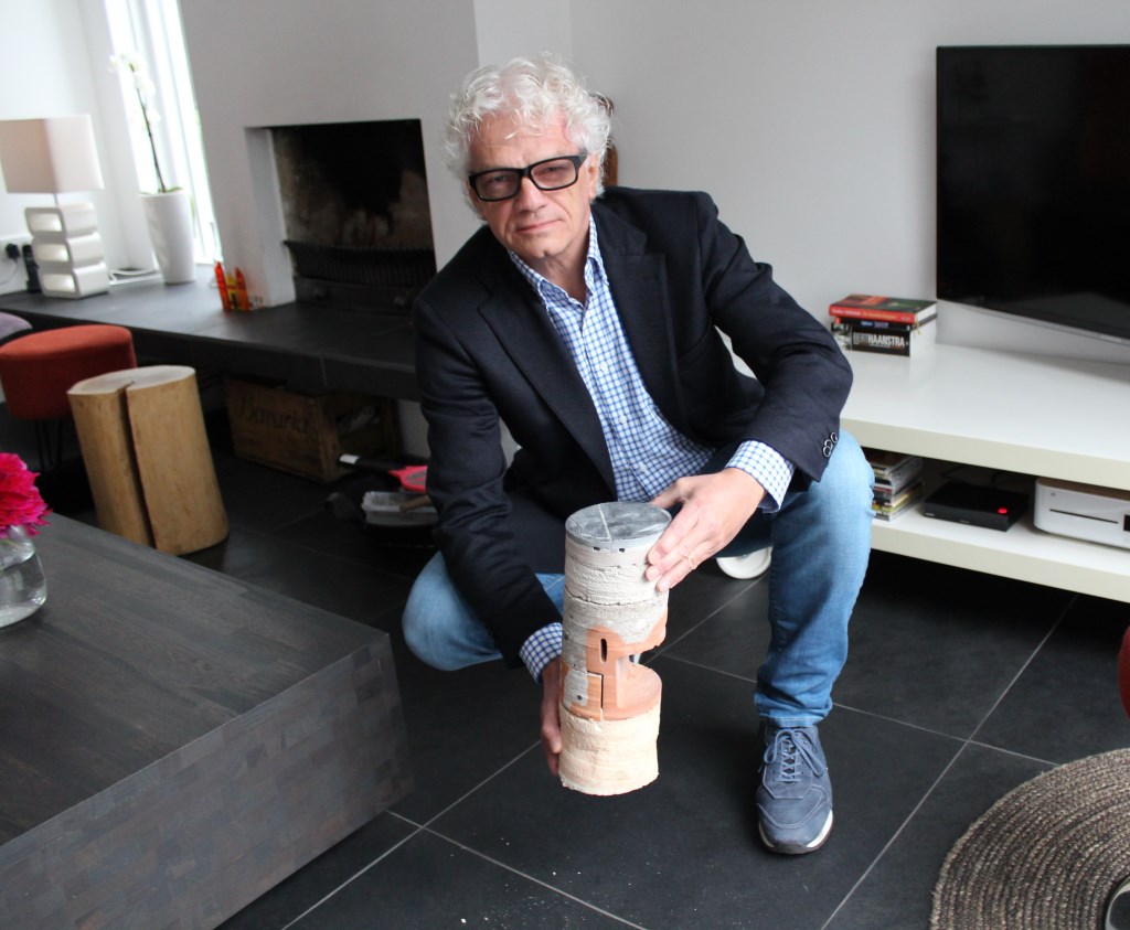 Wim Nijboer laat een doorsnede zien van de geïsoleerde vloer onder hem.