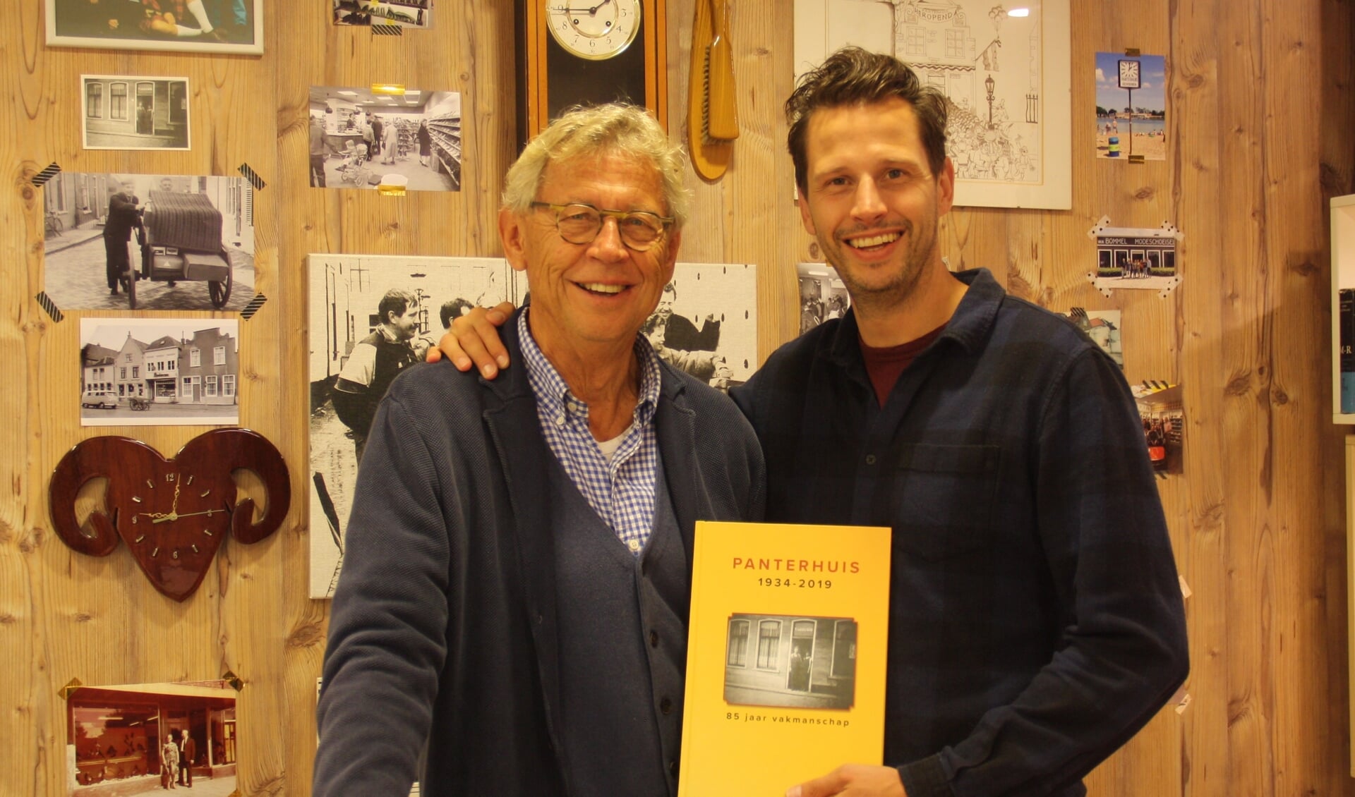 Gerrit en Rutger Leeuwis voor de fotowand met een boek vol geschiedenis.