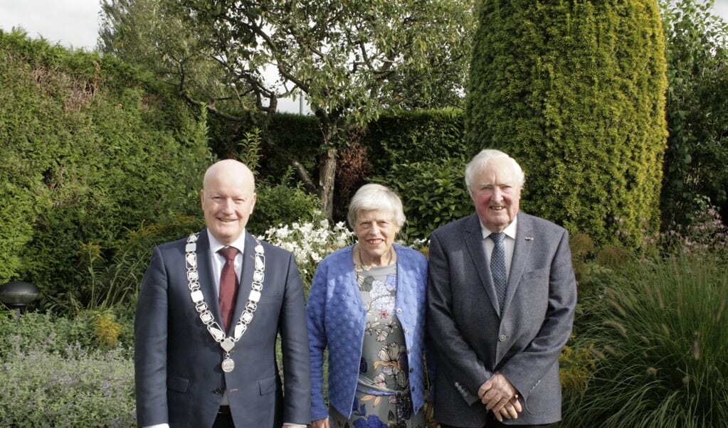Het diamanten echtpaar Anie en Jan Muis met burgemeester Van Bennekom in de zonnige achtertuin