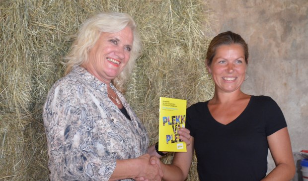 Wethouder Wil Kosterman krijgt de brochure overhandigd door Walenka Broskiwiets