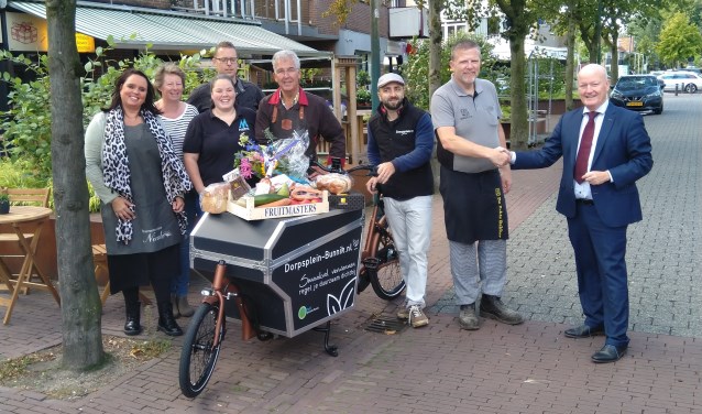 De sleutel van de elektrische bakfiets wordt overhandigd aan de winkeliers van Dorpsplein-bunnik.nl