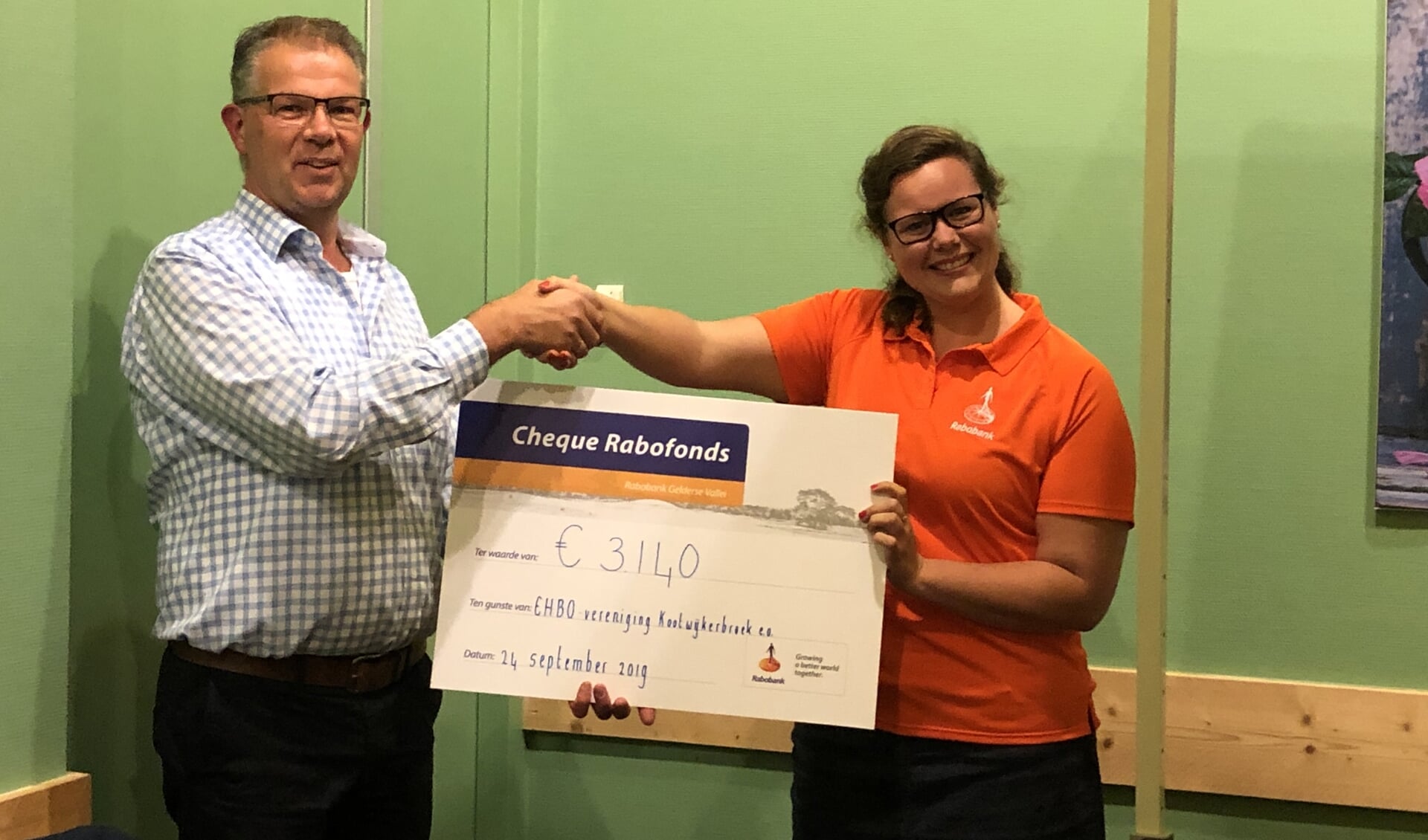 Susanne Jagt overhandigt de cheque aan Cok van der Meer, voorzitter EHBO-vereniging Kootwijkerbroek