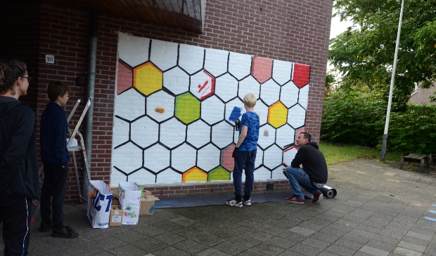 Onder leiding van street-art artiest Daniël van de Haterd maken Leusdense jongeren een fraaie afbeelding op de gevel van 'De Smederij'.