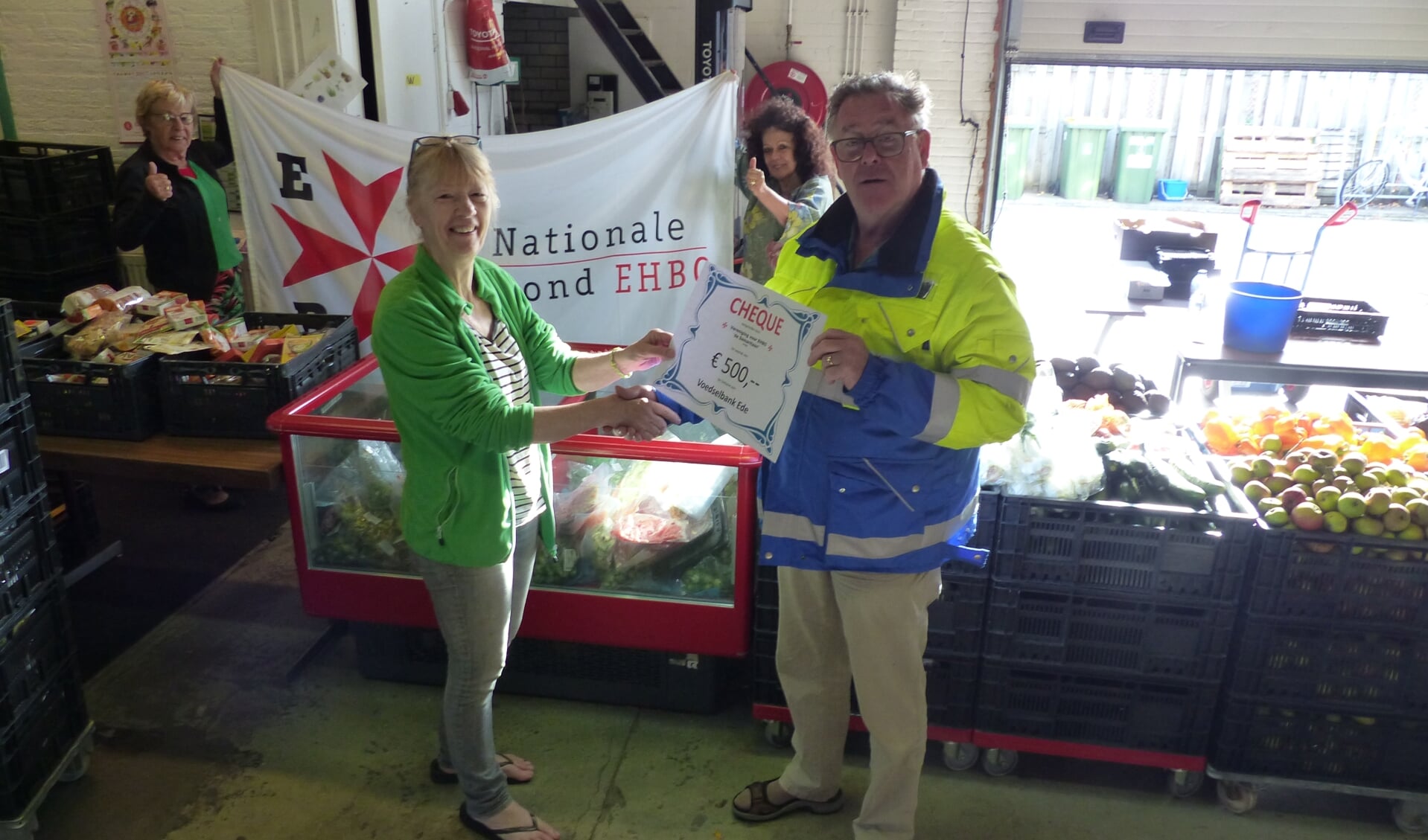   Vereniging voor EHBO 'de Samaritaan' in Ede overhandigt een cheque ter waarde van 500 euro aan de Voedselbank in Ede. Links op foto Anneke Dinger van de Voedselbank, rechts Kees Huikeshoven voorzitter EHBO.