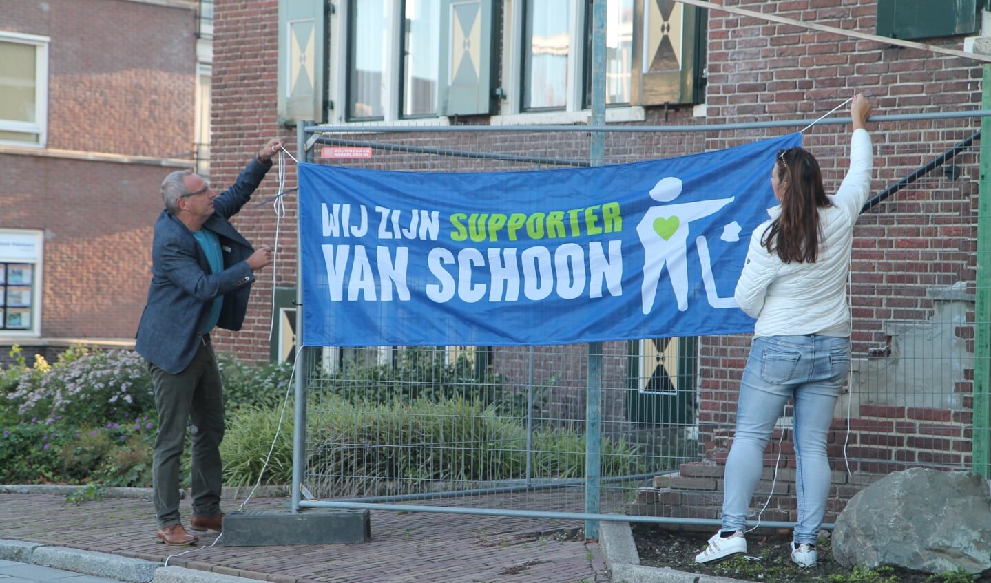 Pieter de Kruif en Martine Tekelenburg hangen de bijbehorende vlag op