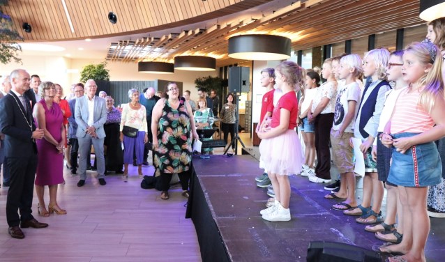 Schoolkinderen zingen het burgemeesterspaar toe