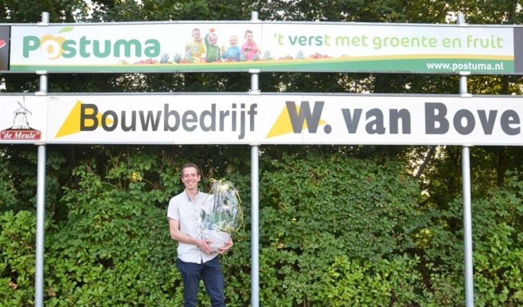 Bedrijfsleider Jarno Kwakkel van Postuma AGF bij het nieuwe reclamebord op sportpark De Heughte van VSCO'61