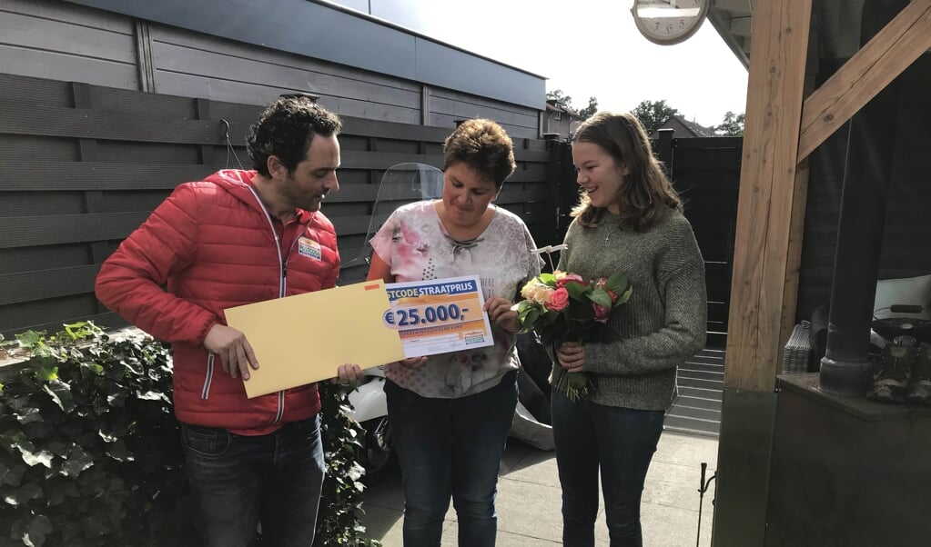 Echtgenote en dochter van winnaar Jan uit Wekerom worden verrast door de Postcode Loterij met de PostcodeStraatprijs-cheque.