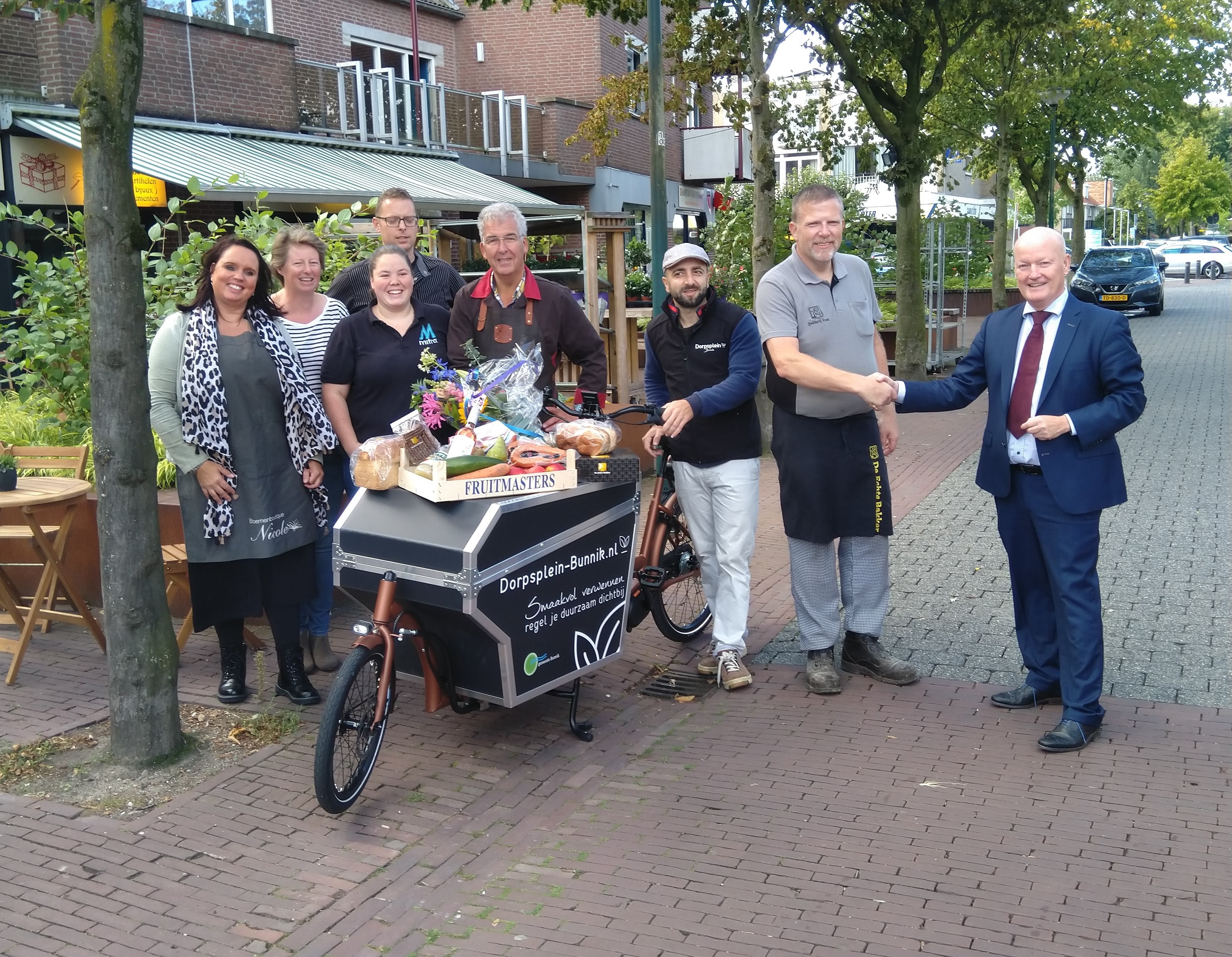 De sleutel van de elektrische bakfiets wordt overhandigd aan de winkeliers van Dorpsplein-bunnik.nl