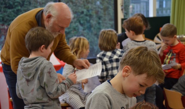 Jan Overweel bekijkt het werk van een van de leerlingen