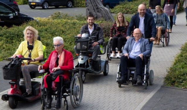Emmy den Heijer (roze vest) en het college ervaren zelf de bereikbaarheid van de binnenstad met scootmobiel of rolstoel
