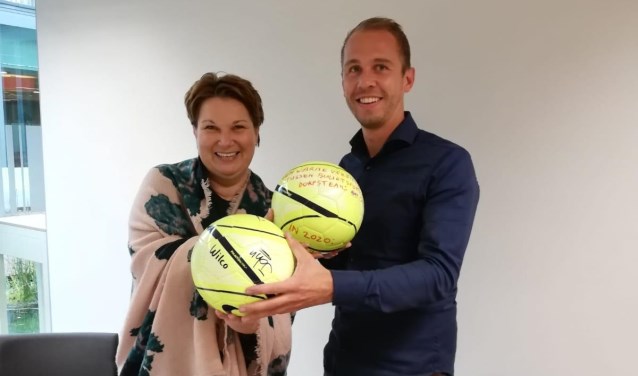 Wethouder Chantal Broekhuis en buurtsportcoach Ruben Buist wisselen ballen uit.