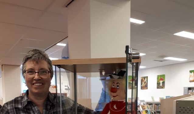 Jantine van de Glind bij enkele van de door haar geëxposeerde clowntjes in de bibliotheek.