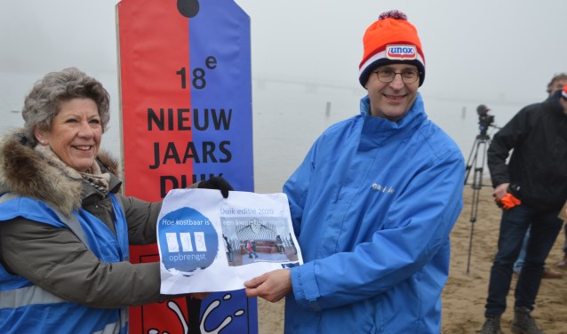 Lida van der Marel (Stichting Herdenkingsmonument Houten) ontvangt de cheque uit handen van Erik de Groot (Stichting Nieuwjaarsduik Houten).