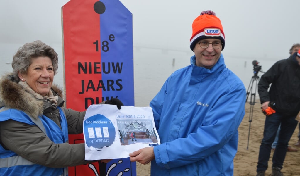 Lida van der Marel (Stichting Herdenkingsmonument Houten) ontvangt de cheque uit handen van Erik de Groot (Stichting Nieuwjaarsduik Houten).