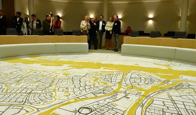 In de vernieuwde raadzaal ligt een tapijt met de plattegrond van de stad