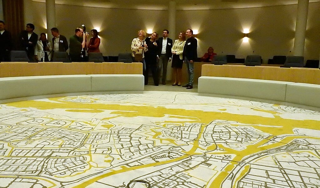 In de vernieuwde raadzaal ligt een tapijt met de plattegrond van de stad