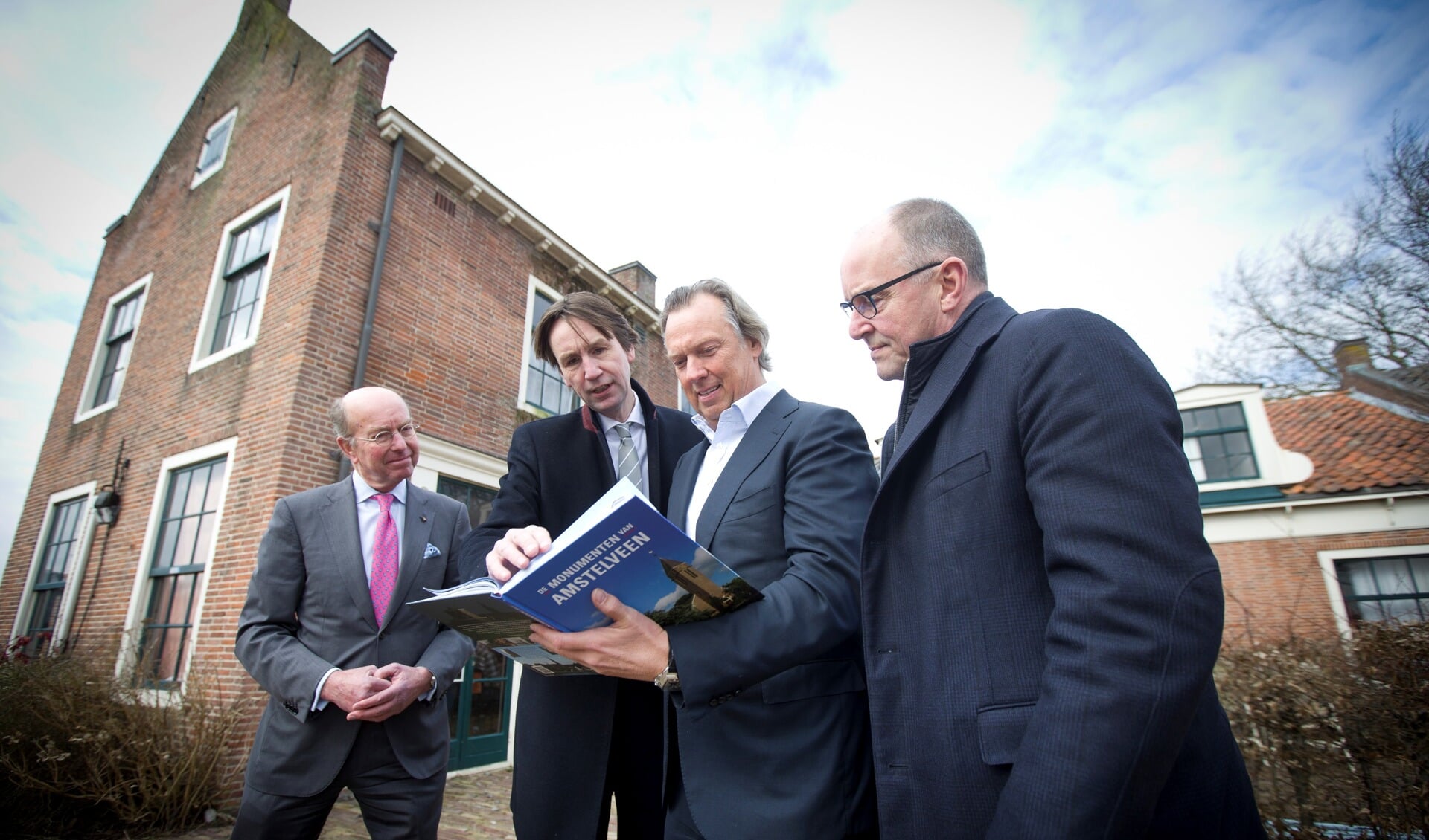 Wethouder Herbert Raat (2e van links) bood Henk Brouwer (CEO Breevast) in maart 2018 het boek Monumenten van Amstelveen ter inspiratie aan in het bijzijn van toenmalig burgemeester Bas Eenhoorn (l) en toenmalig wethouder Peter Bot (r).