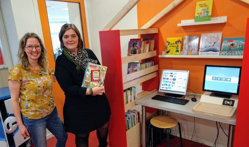 Leescoördinatoren Marjan Vlot (links) en Lian Geluk bij de uitleenplek van de nieuwe schoolbibliotheek.