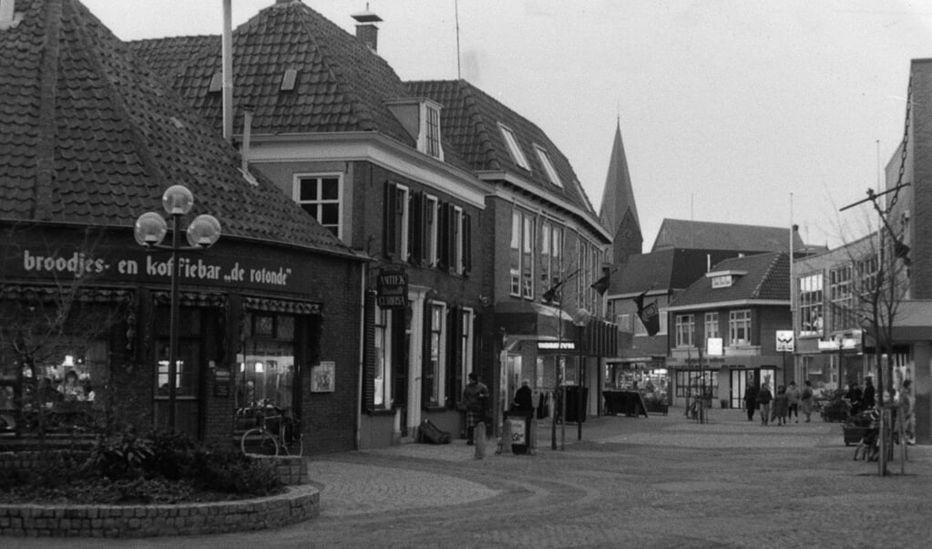 Een prachtige foto van de Langstraat ter hoogte van de Jan van Schaffelaarstraat, gemaakt op 3 januari 1984. Op de hoek de ‘broodjes- en koffiebar ‘de Rotonde’’ waaraan veel wat oudere plaatsgenoten nog wel goede herinneringen zullen hebben. In het oude pand ernaast zat toen een antiek- en curiosazaak. In de voormalige bakkerij van Van der Wal zit al een snackbar. Links daarvan de ‘Kwartet-Verswinkel’ van Piet van den Brink.