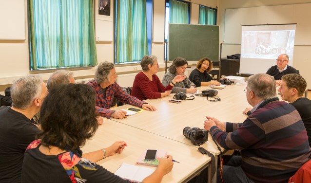Deelnemers aan de lessen fotografie bespreken hun gemaakte werk