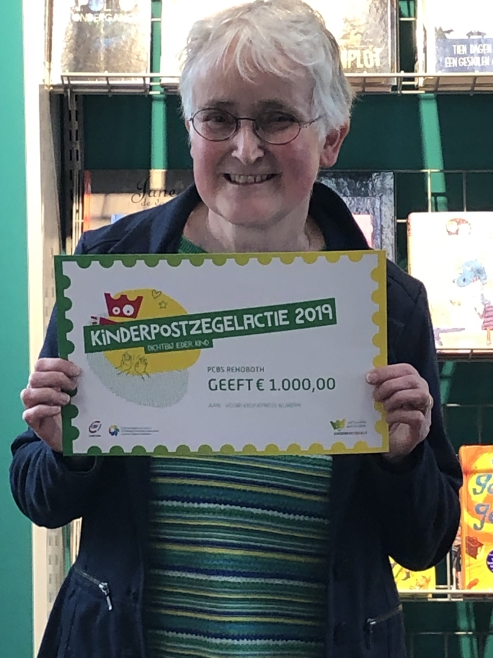 Meta Dekker van de bibliotheek met een cheque van € 1000,- voor de VoorleesExpress