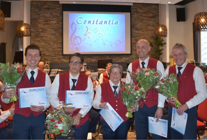 De jubilarissen met insigne, oorkonde en bloemen