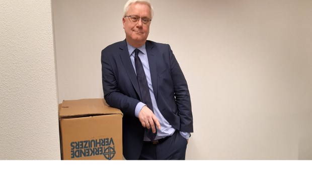 Eric Balemans in een lege werkkamer met verhuisdozen