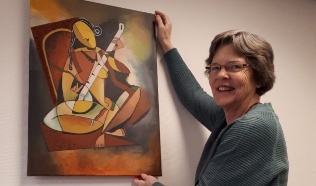 Jacqueline ter Telgte bij één van haar schilderijen in de bibliotheek.