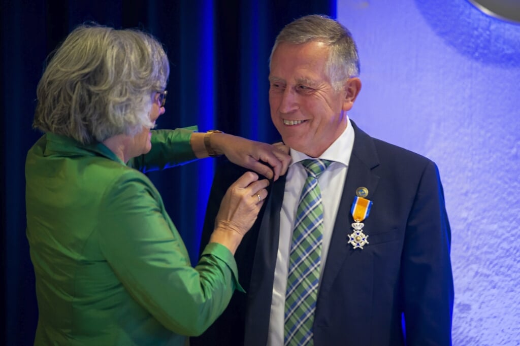 Vertrekkend wethouder Aart de Kruijf werd donderdagavond bij zijn afscheid geridderd in de Orde van Oranje-Nassau. Zijn vrouw Arja speldde hem de versielselen op.