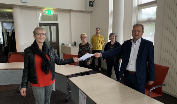 <p>Wethouder Jan Nederveen neemt het tweede deel van de handtekeningen in ontvangst van de activiteitengroep. Archieffoto uit oktober 2020. </p>