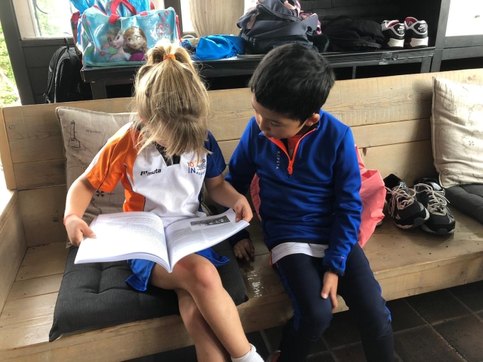 F-pupillen samen verdiept in het jubileumboek