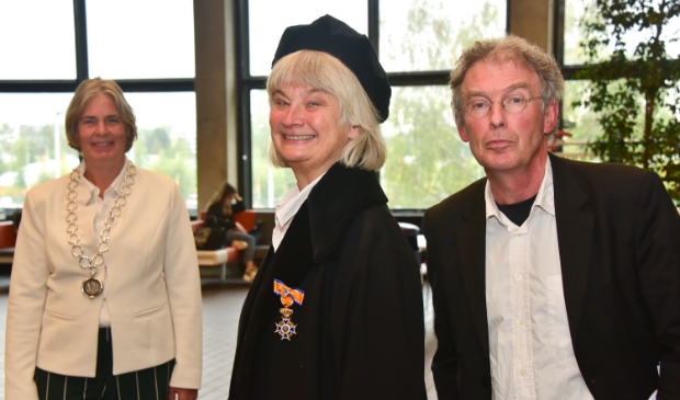<p>De uitreiking. In verband met de anderhalve meter-regel heeft in plaats van de burgemeester de echtgenoot van professor De Vries de onderscheiding opgespeld.</p>