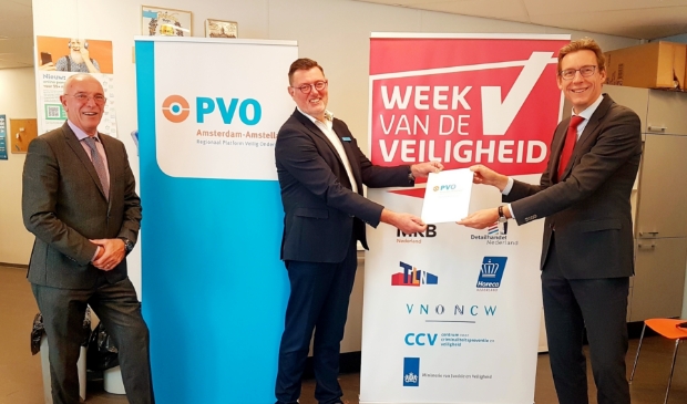 <p>Burgemeester Tjapko Poppens overhandigt PVO map aan Kees Cats. Links Maarten Duijn van het CCV.</p>