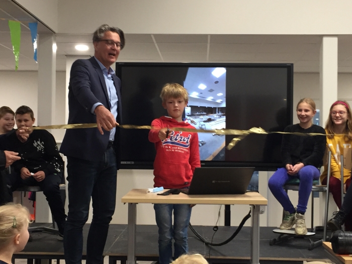 Bestuurder Rob Boerman (KS Fectio) en leerling Mart Hoefnagels verrichten samen de symbolische heropening van de vernieuwde aula van de Barbaraschool.