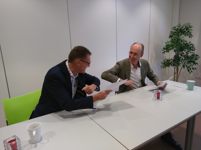 Paul Nagtegaal en Lex Hoefsloot doen elleboogstoot na ondertekening samenwerkingsovereenkomst