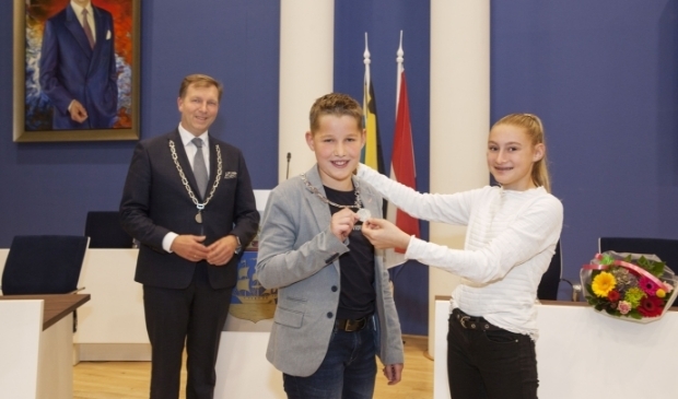 <p>Maud Smit, de vorige kinderburgemeester, hangt Hugo Wennekes de keten om.</p>