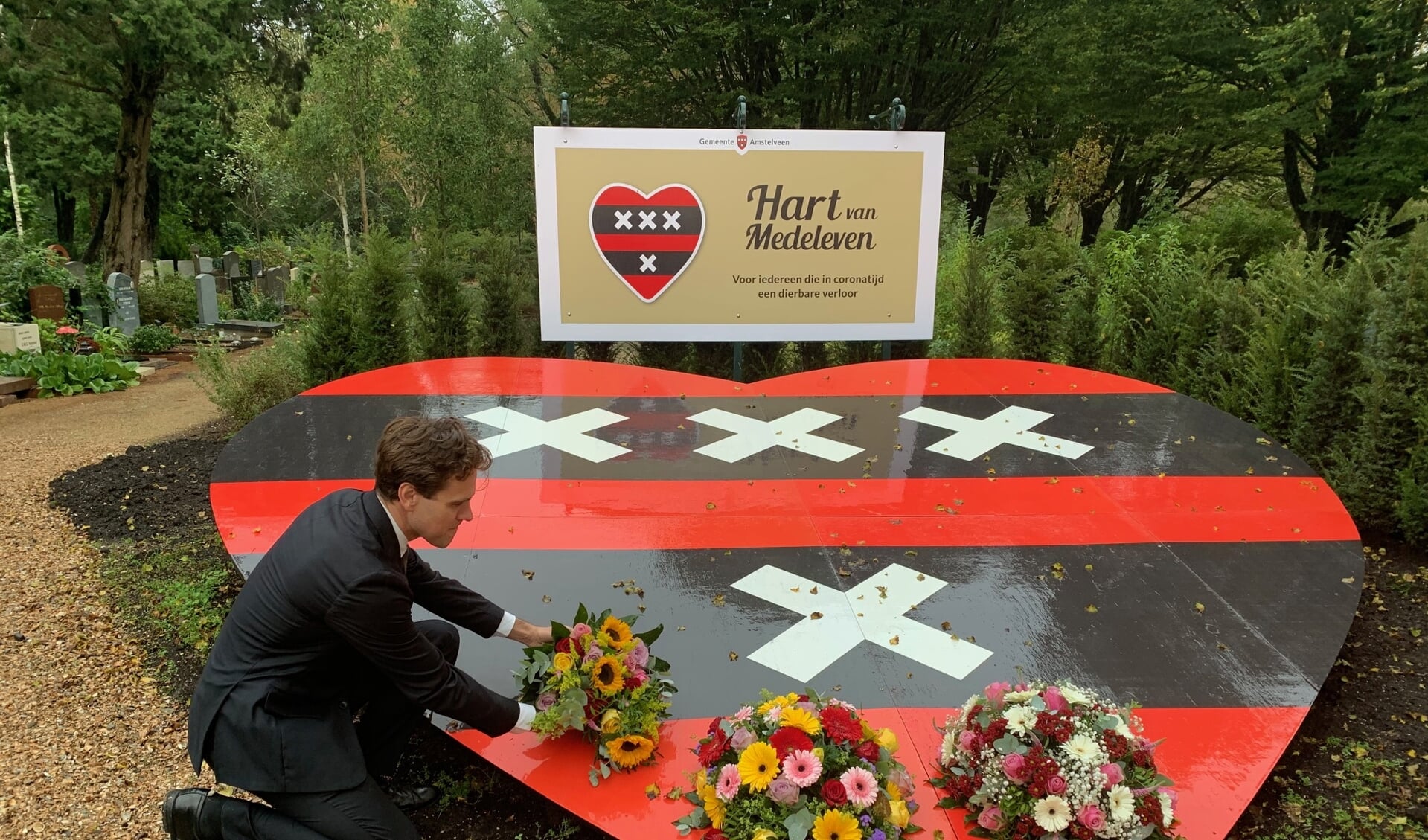 Wethouder Marijn van Ballegooijen legt bloemen bij het monument.