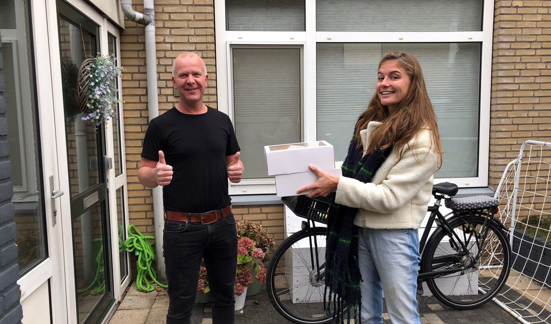 Vrijwilligers van GKV bezorgden zo'n honderd ontbijtjes, Edwin Bos neemt het ontbijtje in ontvangst van Anouk van Velsen 