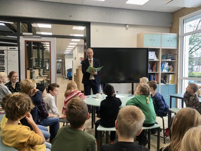 Wethouder Wim Vos leest voor aan groep 4-5 van de Holm